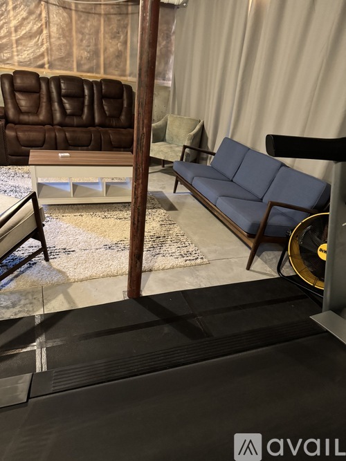 A living room with a brown leather couch and a blue couch.