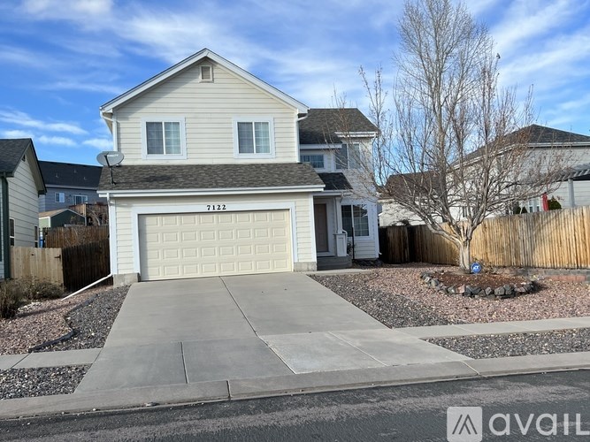 A two-story house with a garage is numbered 7122.