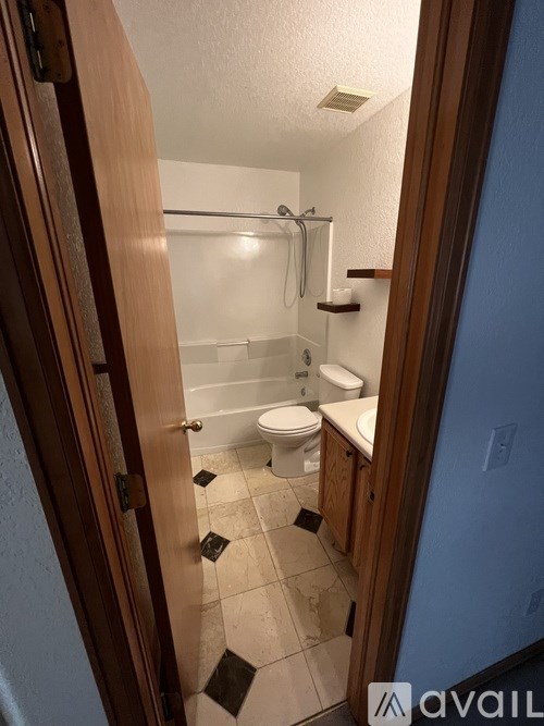 A bathroom with a toilet, sink and shower.