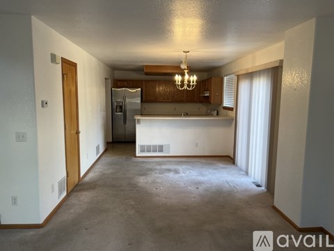 A spacious kitchen and living room with a bar area in the middle.