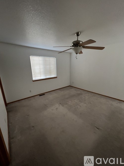 A room with a ceiling fan and a window.
