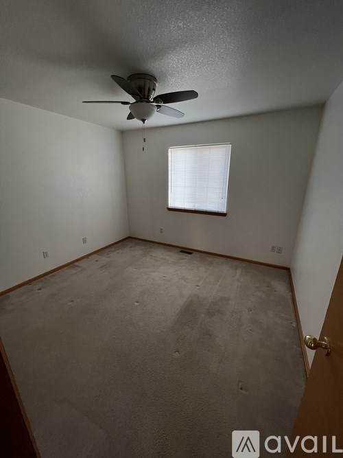 A room with a ceiling fan and a window.