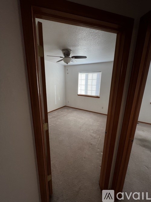 A room with a ceiling fan and a window.