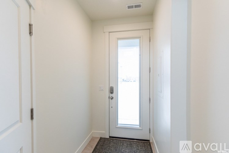 A hallway with a door and a mat on the floor.
