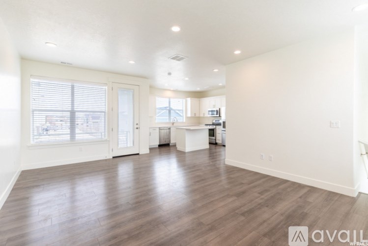 A spacious room with wooden floors and white walls.