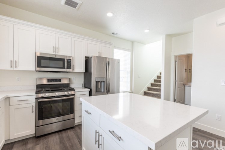 A kitchen with white cabinets and appliances.