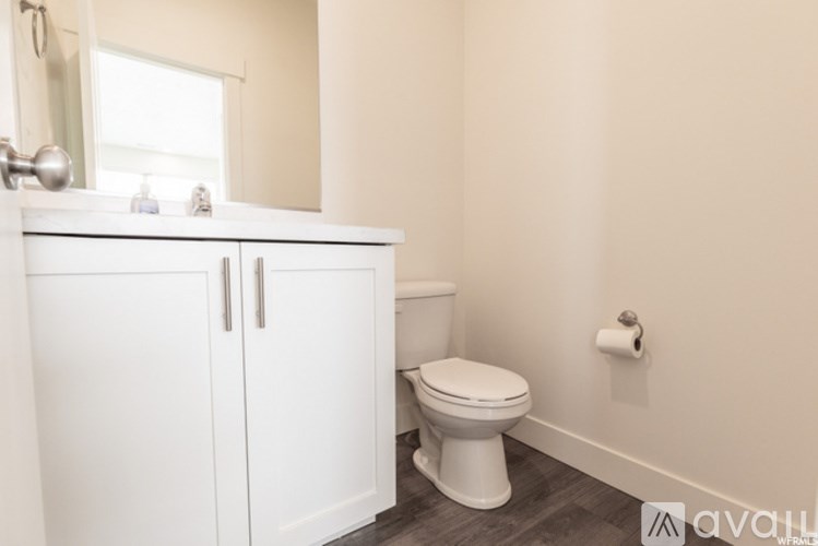 A white toilet sits in a bathroom next to a white cabinet.