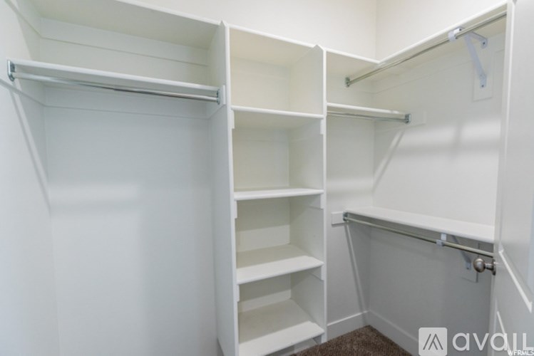 A white walk-in closet with shelves and a door.