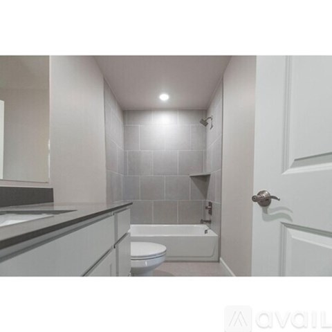 A white bathroom with a toilet, sink, and bathtub.