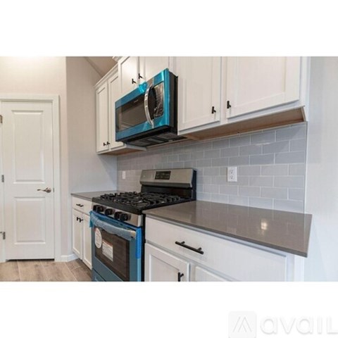A kitchen with a blue oven and white cabinets.