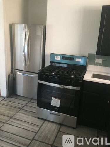 A black oven with a stainless steel refrigerator in the background.