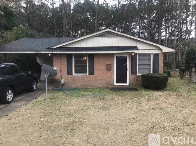 A small house with a black car parked in front.