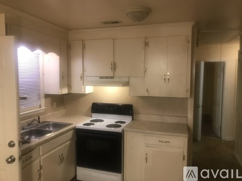 A kitchen with white cabinets and appliances.