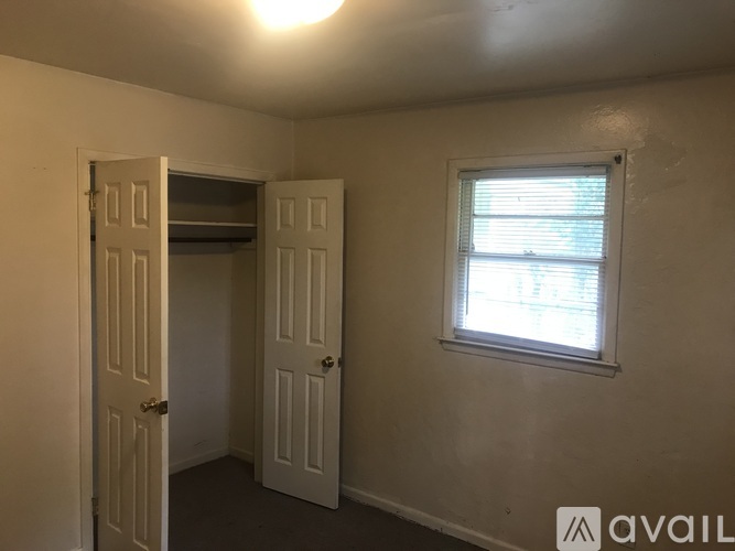 A room with a white door and a window with blinds.