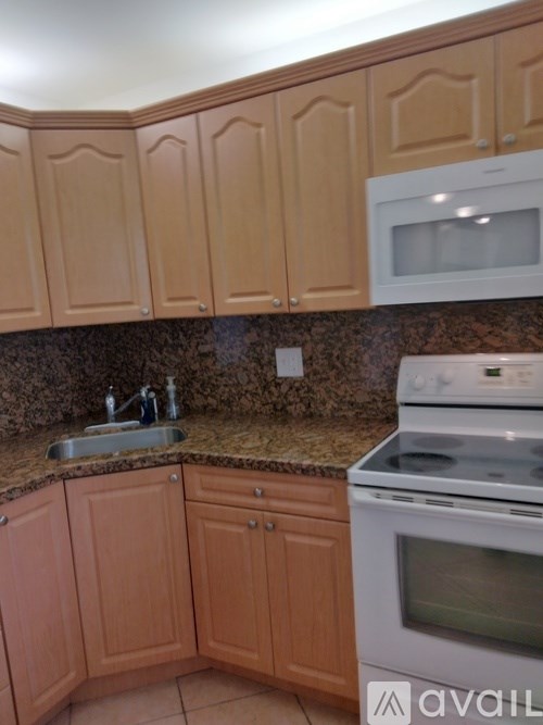 A kitchen with wooden cabinets and a granite countertop.