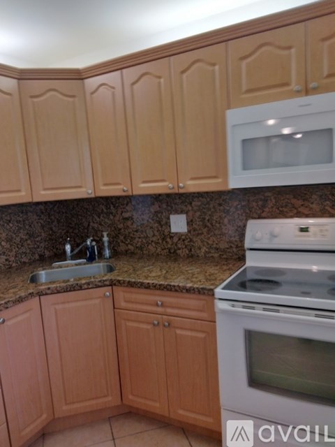 A kitchen with wooden cabinets and a granite countertop.