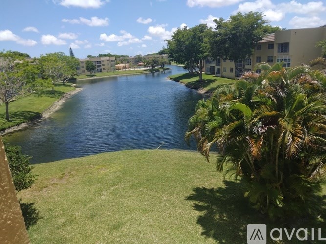 A view of a lake from a balcony with a building in the background.