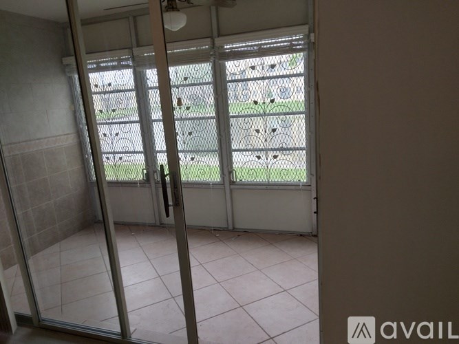 A room with a glass door leading to an outdoor area with a fence.