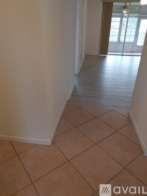 A room with tiled flooring and a doorway leading to another room.