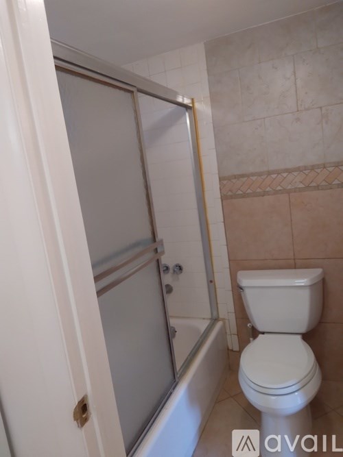 A white toilet sits next to a bathtub in a bathroom.