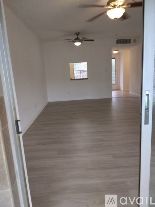 A long hallway with a ceiling fan and light.