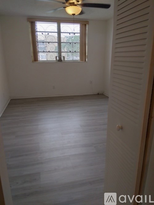 A room with a ceiling fan and a window.