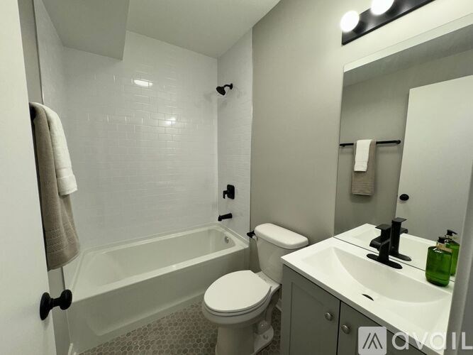 A white bathroom with a toilet, sink, and bathtub.