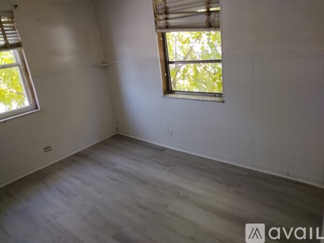 A room with a window and wooden flooring.