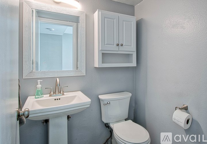 A white toilet sits next to a sink in a bathroom.
