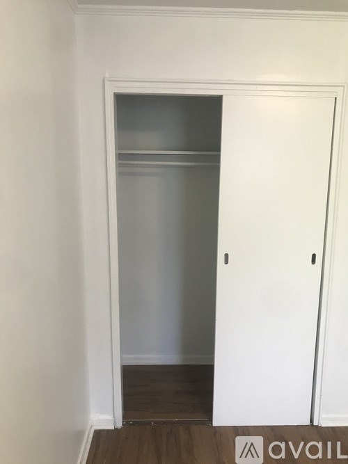 A white door with a glass window is in a room with white walls.