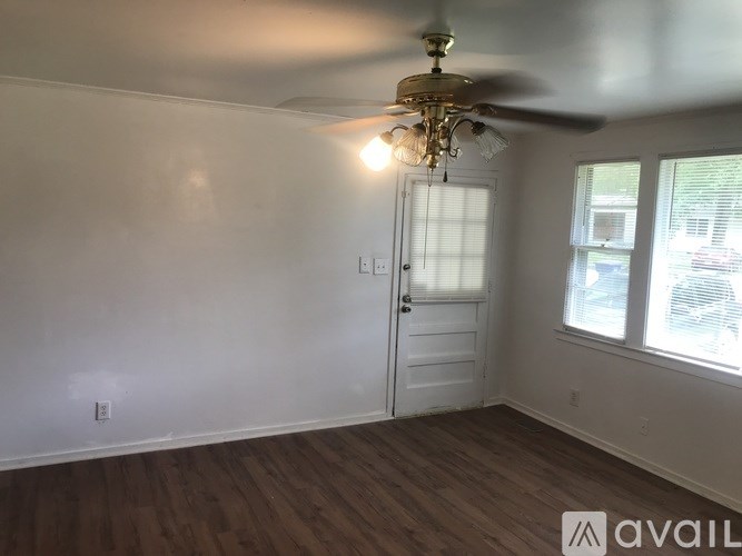 A room with a ceiling fan and a door.