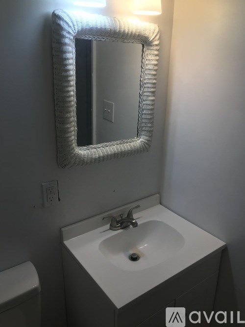 A bathroom with a white sink and mirror.