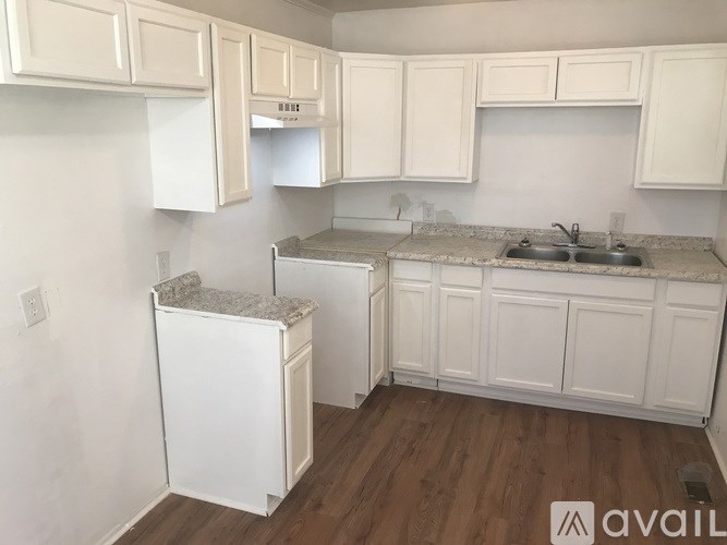 A kitchen with white cabinets and a granite countertop.