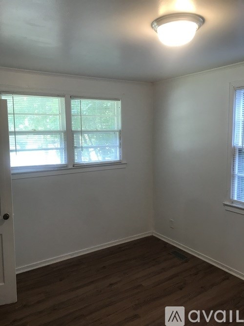 A room with a white door and a window with blinds.