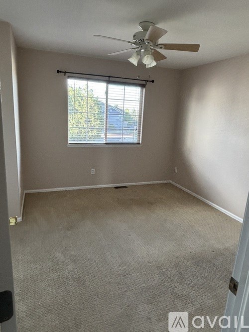 A bedroom with a bed, dresser, and ceiling fan.