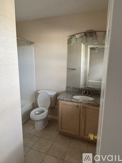 A room with a ceiling fan, a bed, a rug, and a television.