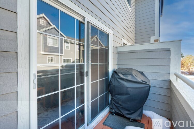 A patio with a grey cover and a black mat.
