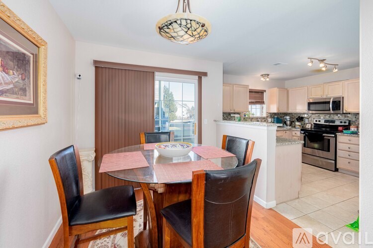 A dining room with a table and chairs.
