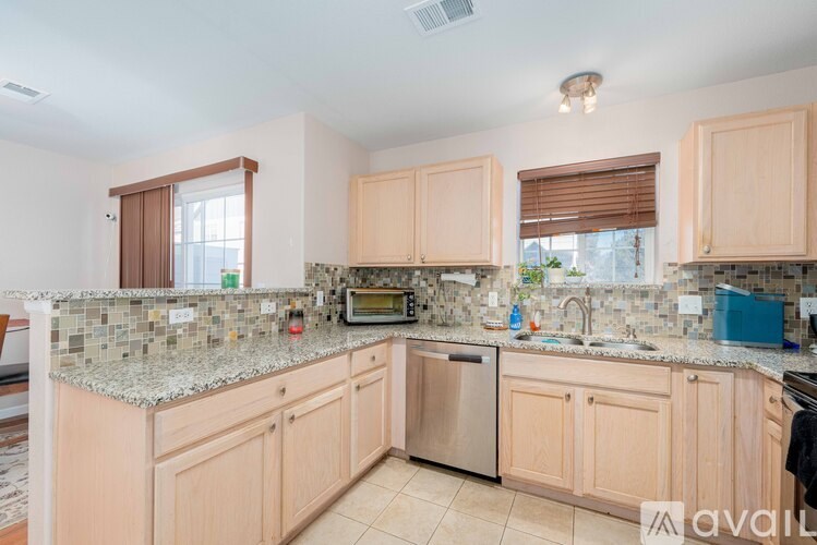 A kitchen with wooden cabinets and granite countertops is available for rent.