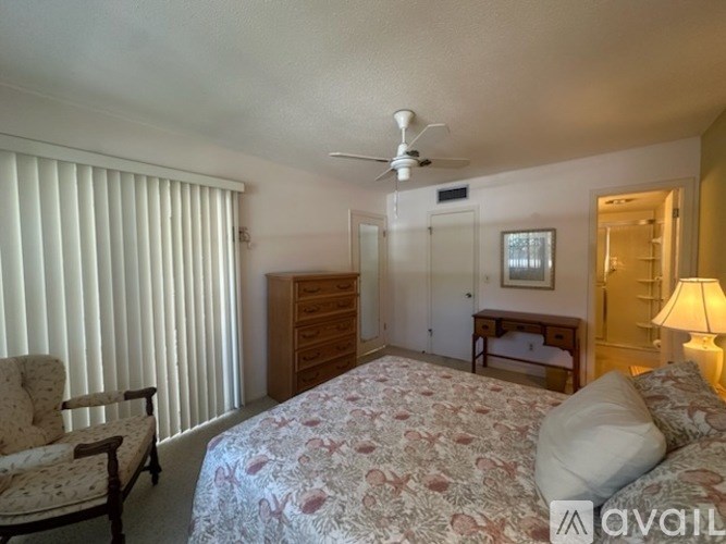 A bedroom with a large bed, a chair, and a dresser.