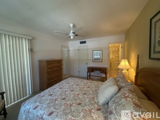 A bedroom with a large bed and a ceiling fan.