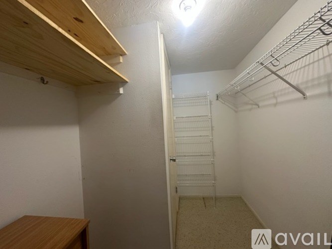 A small room with a closet and a desk.