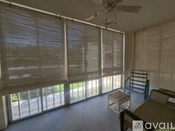 A room with a fan and a table with chairs.
