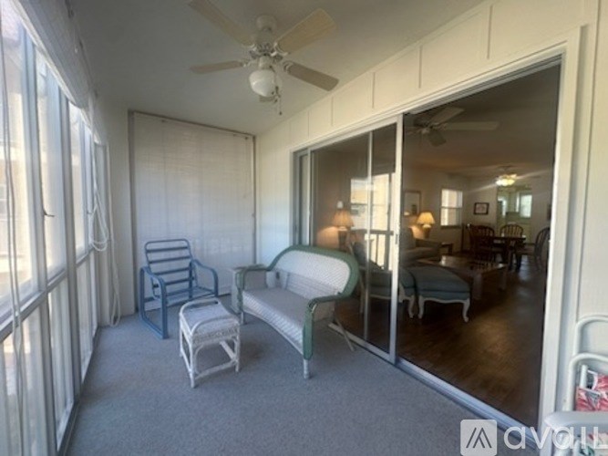 A living room with a blue chair and a white sofa.