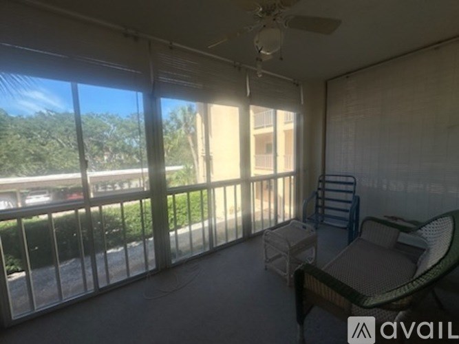 A balcony with a table and chairs overlooking a parking lot.