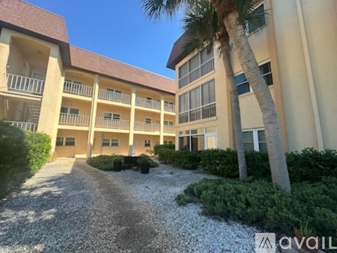 A building with a red roof and a palm tree in front.