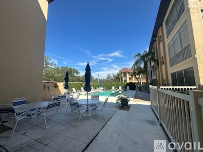 A patio with chairs and a table is set up outside a building.