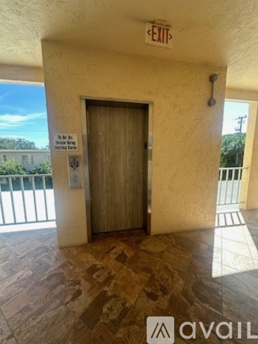 A hallway with a door and exit sign.