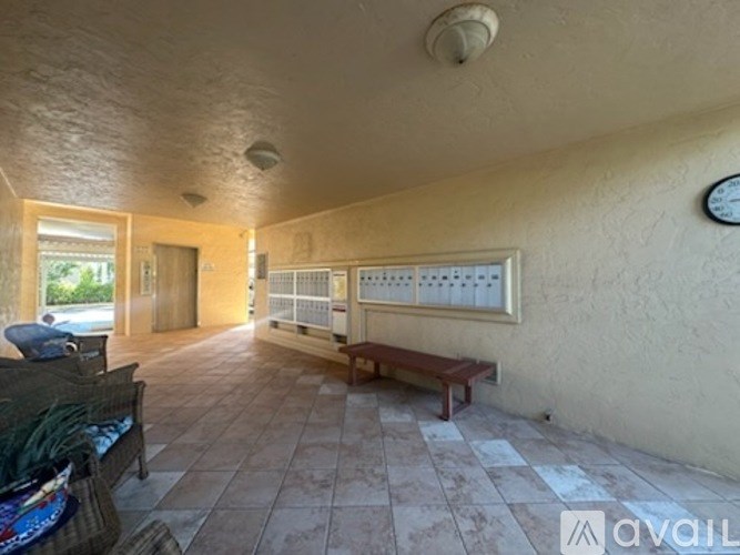 A long hallway with a bench and a clock on the wall.