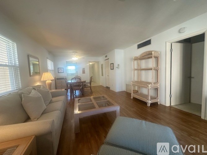 A living room with a couch, coffee table, and a lamp.